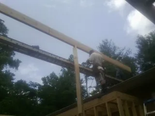 Carpenter setting a ridge beam over a new addition frame — Ice Dam Removal by Roofing Brothers in Darlington